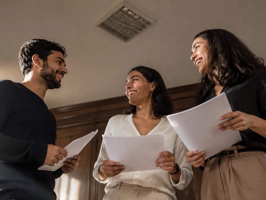 Colegas de mochila nas costas conversando no corredor antes de entrar na sala
